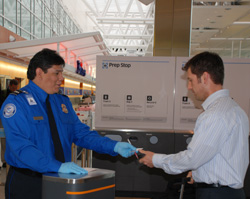 Photo of a woman handing luggage to a TSO