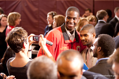 Recording artist Usher pauses for a quick photograph with a City Year AmeriCorps member at the signing ceremony for the Edward M. Kennedy Serve America Act.  President Barack Obama signed the Serve America Act on April 21, 2009 at a Washington DC elementary school, joined by Vice President Biden, First Lady Michelle Obama, Dr, Jill Biden, Members of Congress, former President Clinton, former First Lady Rosalyn Carter, and an audience of nonprofit leaders and national service volunteers. The President was introduced by the bill’s namesake and longtime service champion Senator Kennedy, who co-authored the legislation with Senator Orrin Hatch. 