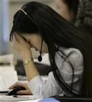 A call center personnel presses her hand to her forehead at an online brokerage company in Tokyo October 23, 2008. REUTERS/Yuriko Nakao