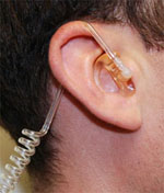 An unobtrusive earpiece similar to those used in the pilot.  Photo by Ann Oh.