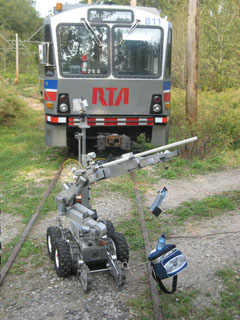 A robot is used to lift a suspected improvised explosive device during a training scenario.