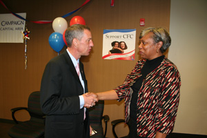 Photo of Honorary campaign chairman Michael P. Golden, assistant administrator for Operational Process and Technology/Chief Technology Officer, shakes hands with Diane Cole, DHS survey manager.