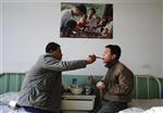 An HIV-infected man feeds his step son, who is also HIV-infected, at a red ribbon primary school known as the Green Harbour in Linfen, Shanxi province November 29, 2008. The school, operated by a hospital since 2004, provides cultural courses and lodging for 13 HIV-infected children aged 8 to 13. By September 2008, China reported about 260,000 HIV positive in total, among whom 77,000 had developed AIDS and 34,000 have died. REUTERS/Stringer