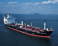 Image of a barge in the ocean near a major city