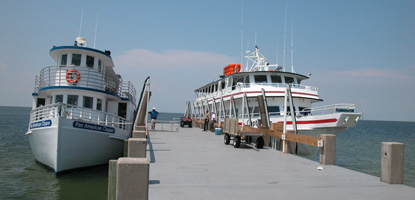 Two passenger ferries, Pan American Clipper and Captain Pete, are docked at the West Ship Island pier on a clear, sunny summer day.