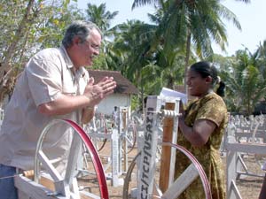 Photo: Jeff Allen of USAID Sri Lanka presents Piyawathi 
        De Silva new coir spinning equipment. She is among 600 tsunami-affected village artisans to receive the donation, which also included a 
        quantity of raw materials.  Photo: USAID/Sri Lanka