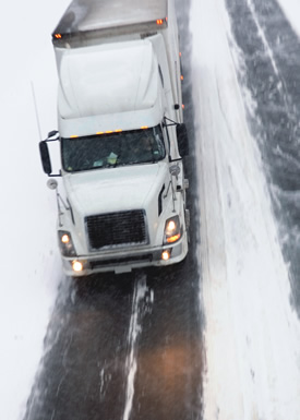 A truck driving down an icy roadway