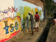 Local residents prepare a mural promoting the peace-building process in Comoro, East Timor.