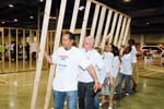 Volunteers including Corporation for National and Community Service Chief Financial Officer Jerry Bridges, second from the left, and Corporation Chief Operating Officer Liz Seale, fourth from left, raise a portion of the frame of the house that will be shipped from the National Conference on Volunteering and Service in Philadelphia to Gulfport, MS. Once it is finished in Gulfport, the house will become the home of a family left homeless by the hurricanes that struck the Gulf Coast in 2005. Project partners included YouthBuild Philadelphia Charter School and YouthBuild USA. AmeriCorps members serving with the YouthBuild Philadelphia Charter School helped manage the build.