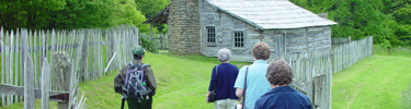 Park rangers take visitors back in time among the historic log cabins of the Hensley Settlement tour.