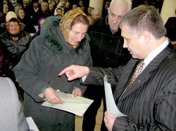 Kyiv Oblast Governor Y. Zhovtiak presents a couple with the title to their land in March 2006.