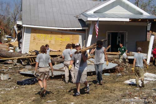 AmeriCorps members clear debris from a house on East Second Street in Pass Christian, Miss.