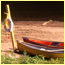 Canoes and a life-saving ring on a beach along a river