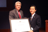 U.S. Representative (LA-2) Anh "Joseph" Cao accepts the “Outstanding American by Choice” recognition from USCIS Acting Deputy Director Michael Aytes at the U.S. Capitol Visitor Center in Washington, DC, Apr. 3, 2009