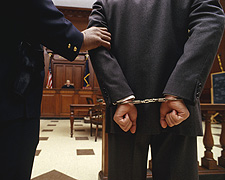 Man in handcuffs led into a courtroom
