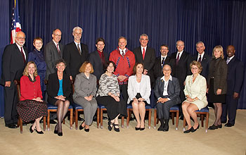 Group of 19 people in two rows, one seated and the other standing