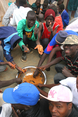 Students enjoy a hot meal at a community-based school in Mboumba, Senegal