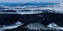 Color aerial photograph of snow covered mesas and peaks in the volcanic field.