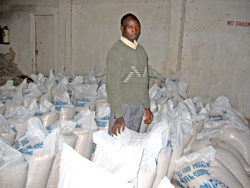 Sam Arapsatya inspects warehoused maize used as collateral for his first-ever loan in Kapchorwa, Uganda. When the price is right, he can sell the maize and repay the bank.