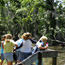 Girls peer over a railing into the canal at the Barataria Preserve