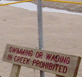 sign on the beach prohibiting swimming