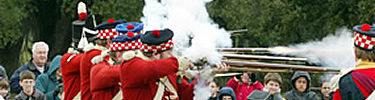 Men dressed as British soldiers from the 1815 Battle of New Orleans shoot muskets at Chalmette Battlefield.