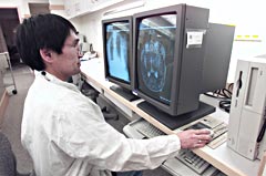 Photo of a technician viewing medical imagery