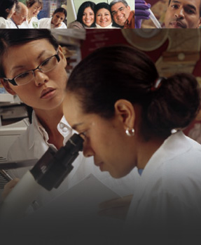 Two female researchers - One looking into a microscope as the other looks on