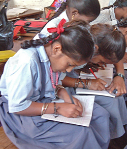 A student studies decimals with the support of radio broadcast instruction at a school in Tuskar Town, located in the Greater Bangalore area, southern India.