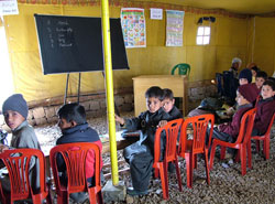 Second-graders in Pak Gali Boys School in Poonch District were some of the first students to use new tent classrooms provided by USAID after the devastating October 2005 earthquake. Outfitted with desks and chairs, the classrooms helped schoolchildren reestablish normal routines after the quake.