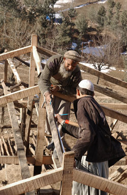 Master builders in the Chatterplain region of Mansera District train local villagers how to con-struct earthquake resistant transition shelters.