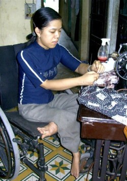 Photo of: Li Thi Bich Hien at sewing machine.