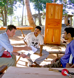 Survey team leader Ross Ferguson, left, discusses second-tier loans with carpenters near Baucau, East Timor’s second largest city.