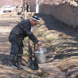 A Navobod villager collects water from a USAID-funded pump located steps away from his home.