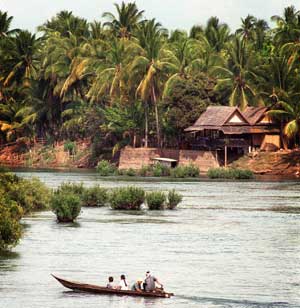 A small boat crosses the Mekong River, Laos, February 9, 2001. [© AP Images]