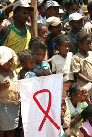 Photo of children attending a health festival in Tolonguina, Madagascar, hold a flag to remember those lost to HIV/AIDS.