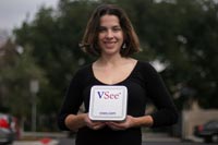 Photo of Colleen Beeson holding the hardware component of virtual office system.