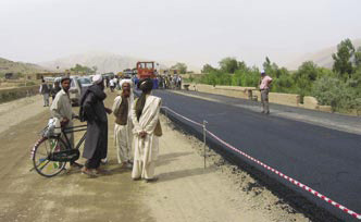Afghan men observing the paving of the Kabul-Kandahar highway.