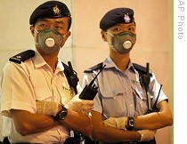 Police officers wearing masks, seal off Metro Park Hotel in Hong Kong, where first confirmed swine flu victim was staying, 01 May 2009