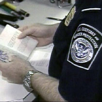 A U.S. Customs officer inspects visa documentation