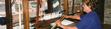 Volunteer demonstrating how to weave.