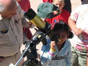 visitors peering at the sun through a solar telescope