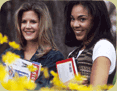 Two smiling young women holding books