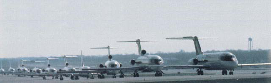 Image of eleven aircraft in que on runway.