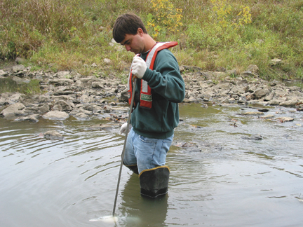 USGS hydrographer collecting a water sample from Mill Creek.