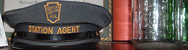 Station agent hat from the Bangor and Aroostook Railroad sits next to a historic bottle.