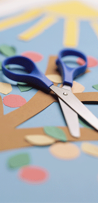 Click to open page for puzzles and other games. Photo of a pair of scissors and colorful paper cuts