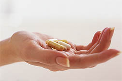 Photo: A hand holding pills.