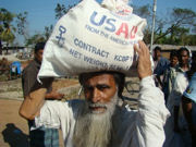 A 60-year-old resident of one of the cyclone-affected areas of Bangladesh receives flour, oil, and peas from USAID after Cyclone Sidr