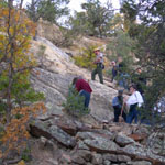 A Park Ranger guides a group to the top of the bluff at El Morro.